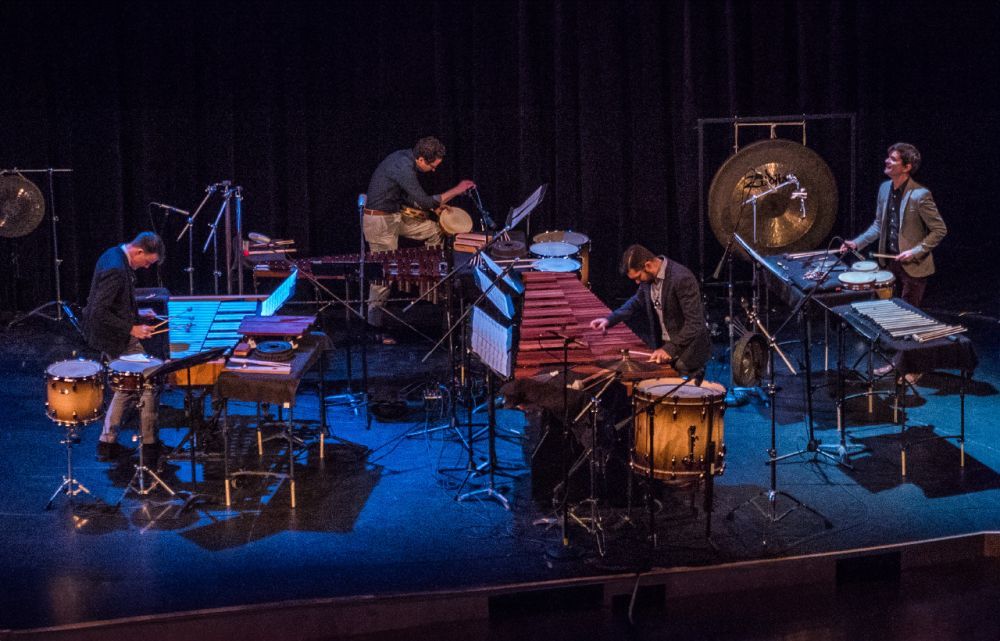 A group of musicians on stage playing various percussion instruments.
